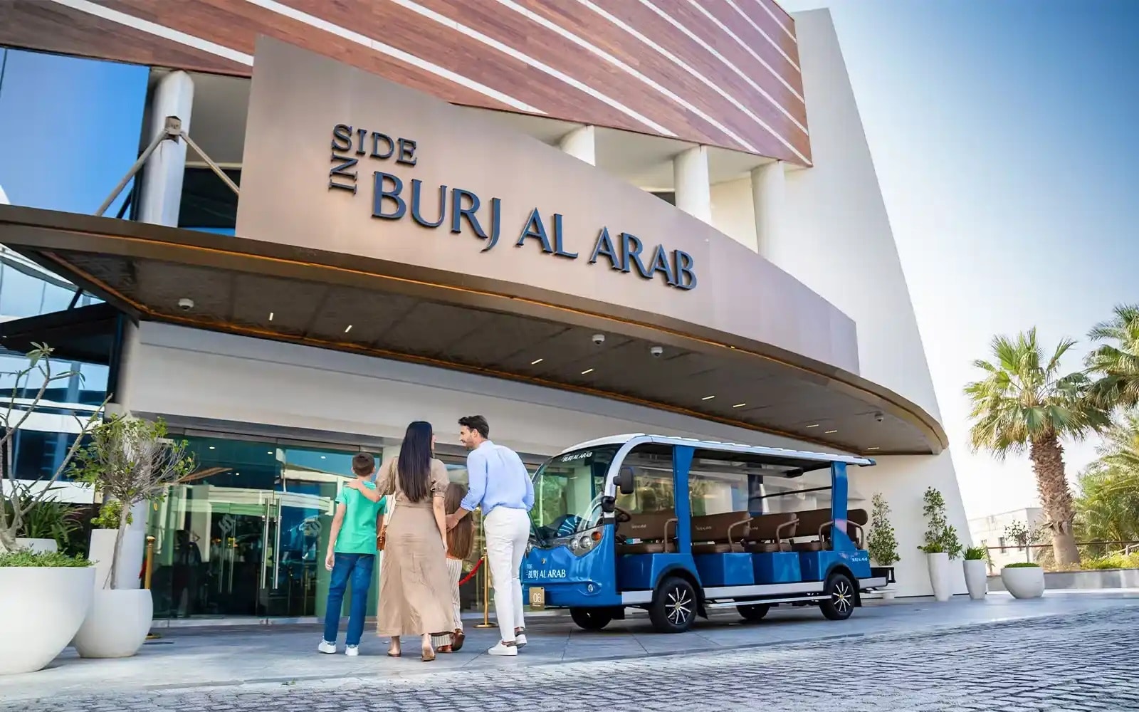 مسافر يصل إلى فندق جيد القيمة في دبي، يظهر الراحة والرضا عن الاختيار الذكي بميزانية معقولة.