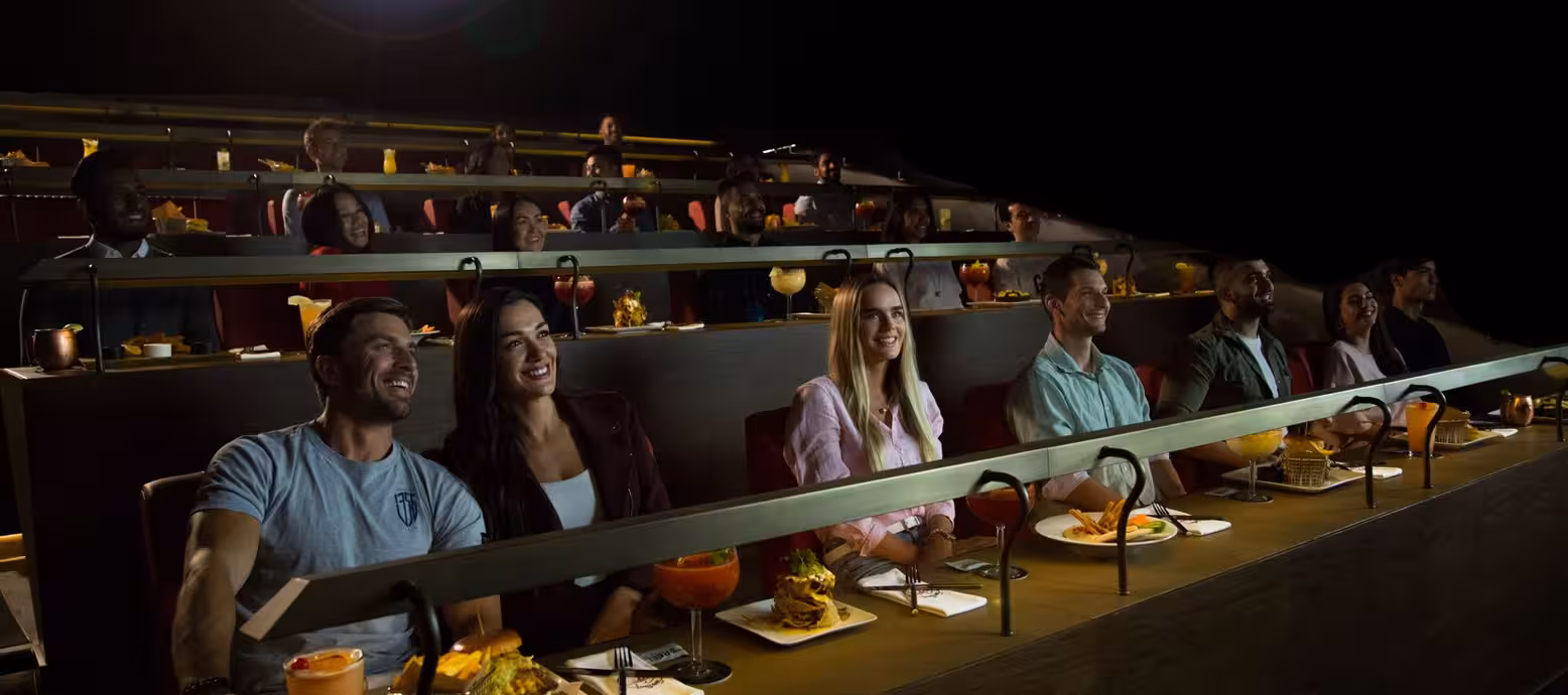 زوار يستمتعون بتجربة Dine‑In في Reel Cinemas داخل دبي مول، حيث يمكنهم مشاهدة أحدث الأفلام على شاشة كبيرة مع تناول وجبات طعام كاملة في مقاعد مريحة أثناء العرض السينمائي.